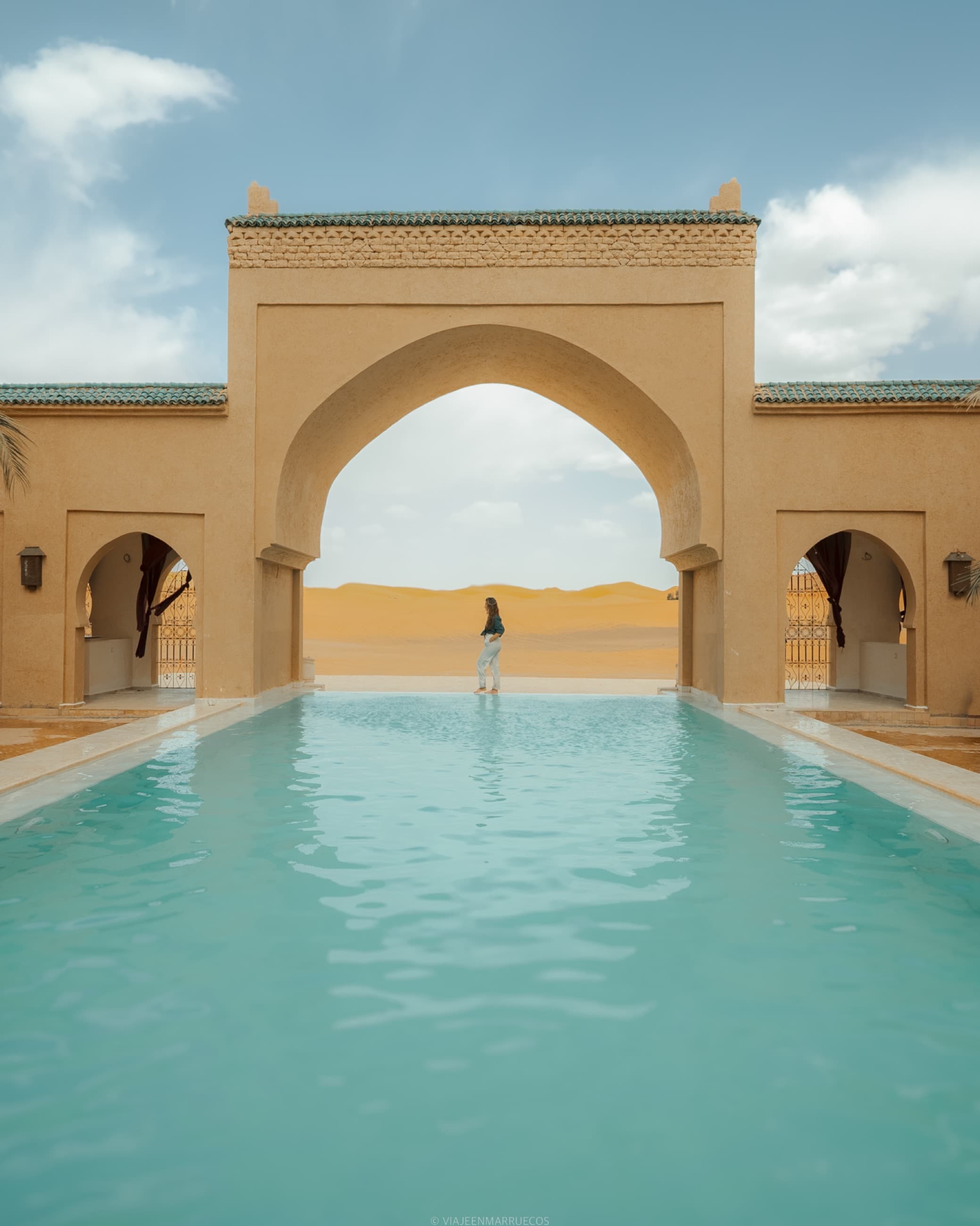 La alberca de Sahara Pearl bajo el gran arco, con las dunas al fondo